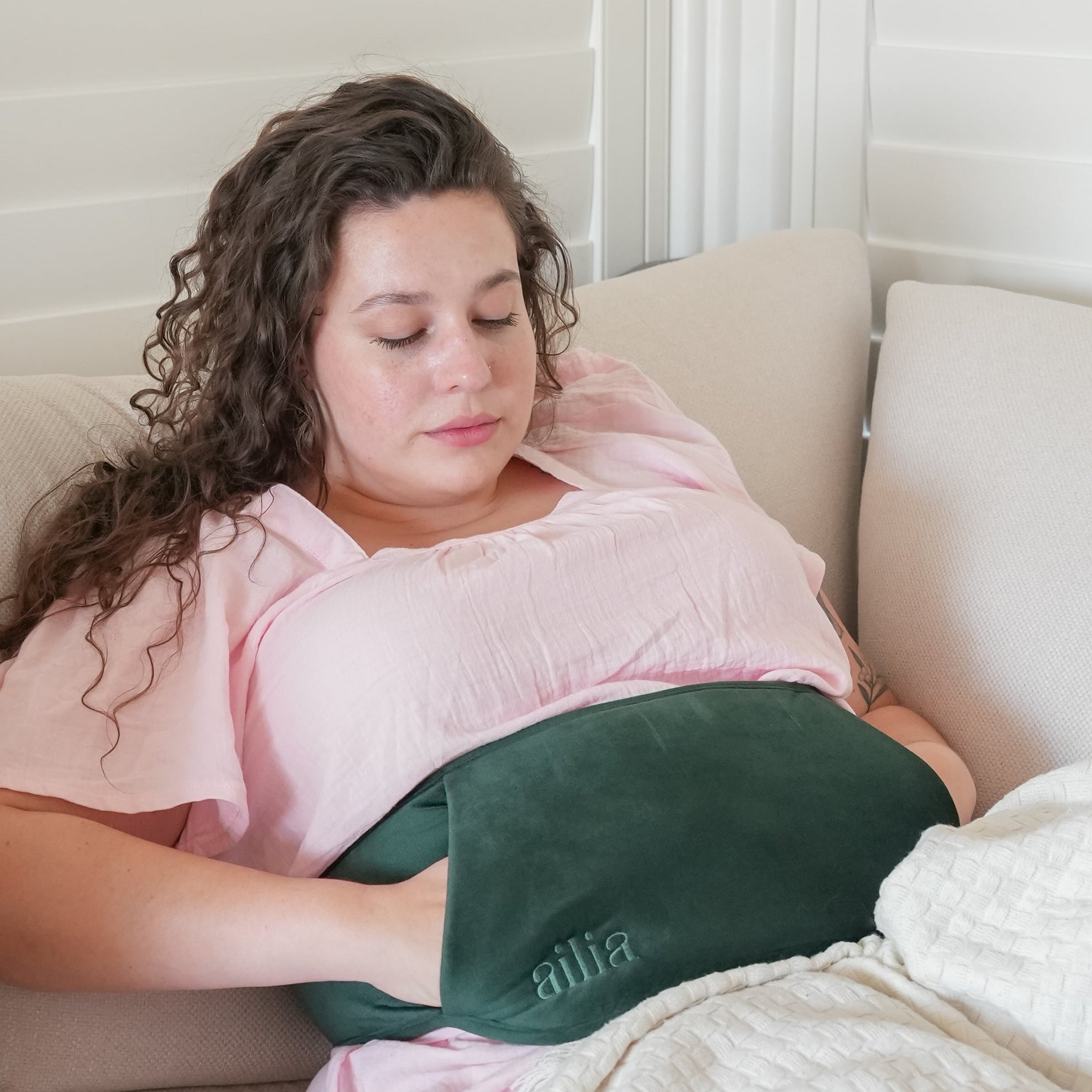 Woman lying on a couch with her Ailia Bottle Body Strap.